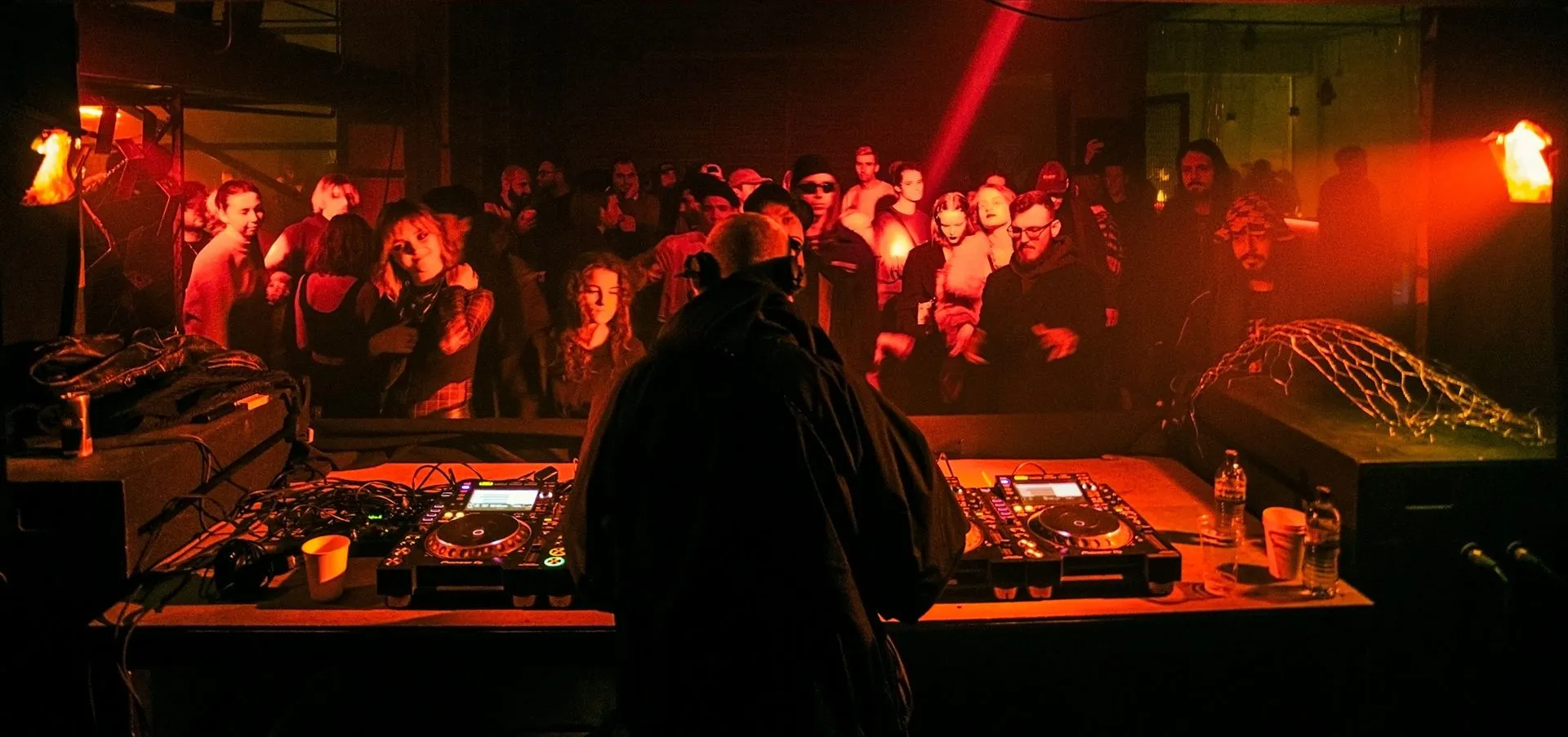 DJ tocando para o público em festa de música eletrônica